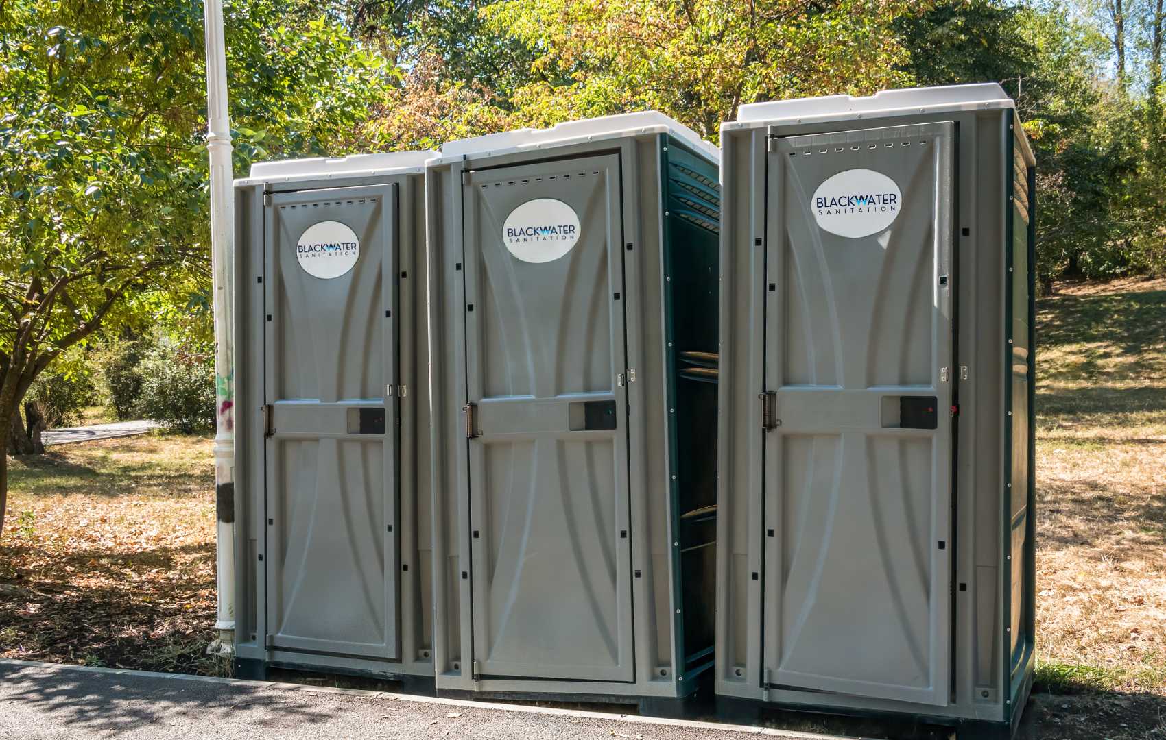 3 portable toilets standing in a row